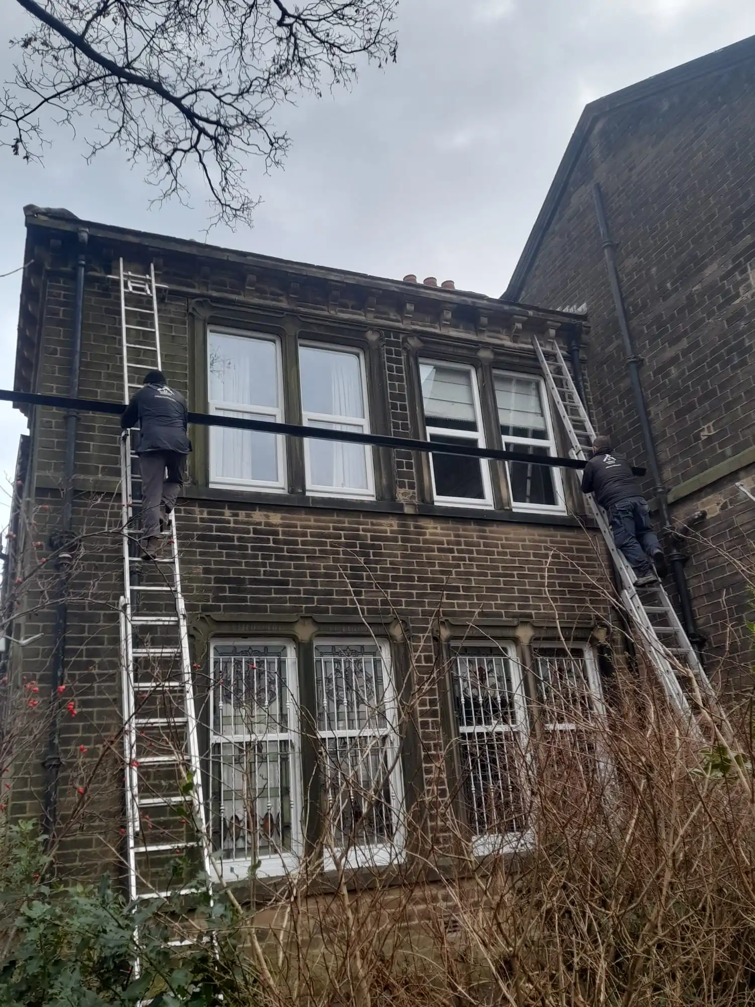 Our team fitting seamless guttering to a stone house in Bradford